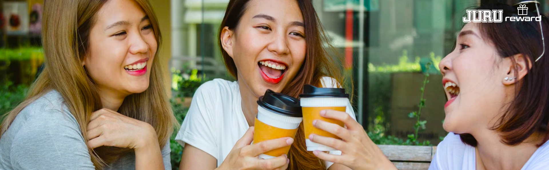 Friends laughing together while redeeming JuruReward vouchers over coffee